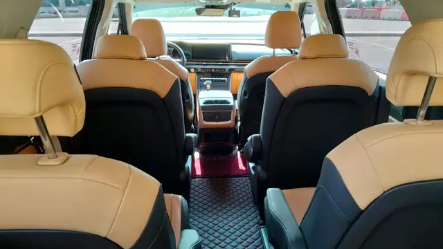 Beige leather captain seats in the front cabin of our Kia Carnival